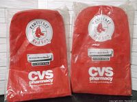 Photo showing two new red Pawtucket Red Sox backpacks in packaging with CVS Pharmacy branding and team logo.