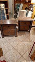 Photo showing two wooden bedside tables side by side, each with two drawers and metal handles, visible water damage on top surfaces.