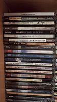 Front view of stacked CD spines showing titles and artists, mainly country and bluegrass music.