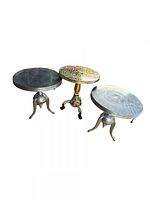 Photo showing all three vintage tables: two silver metal round tables and one colorful multicolored painted table with tripod base.