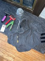 Overview of all items in lot including grooming tools and Dog Thunder shirt on counter surface