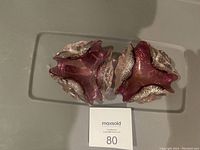 Two vintage Murano art glass ashtrays in shades of pink with gold flecks, displayed from the top down showing their organic shapes and coloration.