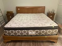 Full front view of assembled queen bed frame with mattress and box spring