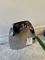 Front view of the stainless steel oval vase showing reflective surface and shape