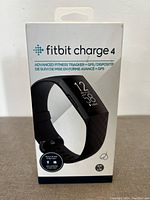 Front of Fitbit Charge 4 box showing product image, brand, and features like built-in GPS and Fitbit Pay.
