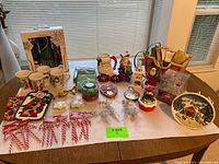 Full table view showing all Christmas holiday items including candy canes, Santa mugs, kitchen mitts, glassware, and other decorations.