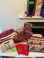 Overview of Christmas pillows, blankets, stockings, and string lights on table