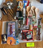 Overview of various cooking utensils including wooden spoons, metal spoons, ladle, kitchen timer, and accessories.