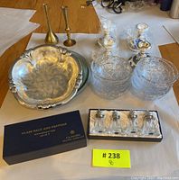 All items arranged on table showing boxed salt and pepper shakers, silver tray, crystal bowls and brass candle holders