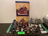 Full view of all items together including boxed houses, figurines, trees, and lighting accessories