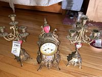 Front view of antique clock and two matching candelabras showing overall design and condition