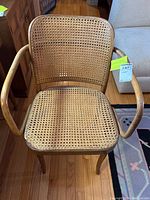 Front view of bentwood cane armchair showing the curved armrests, woven cane seat and backrest, and wooden legs.