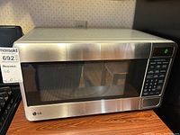 Front view of LG microwave oven showing stainless steel finish, large door window, and control panel.