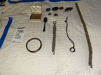 Overall view of all jewelry pieces laid out on white bedspread