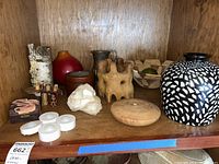 Shelf with all items showing multiple decorative objects such as vases, bowls, boxes, and various trinket objects made of wood, ceramic, and natural materials.