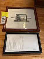 Photo showing both framed prints side by side on the floor with measurement notes.