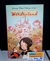 Front cover of the book showing illustrated characters, castle, and title Wonderland by Tommy Kovac and Sonny Liew.