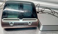 Dymo LabelWriter Twin Turbo printer and USPS postal scale with cords visible