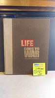 Full view of front cover of vintage 'LIFE Goes to War' hardcover book with note indicating the lot number and item description.