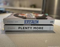 Side view of two cookbooks stacked showing titles Jerusalem and Plenty More by Ottolenghi.