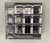 Close front view of one black and white NYC building photograph on raised box panel showing architectural details and fire escape