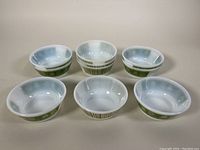 Top and side views of four milk glass cereal bowls with a green floral and geometric pattern in very good condition.