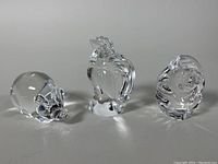 Three crystal figurines (pig, rooster, fish) shown from front view on a plain background.