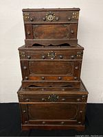 Three wooden nesting storage boxes stacked from largest to smallest, showing overall condition and design.