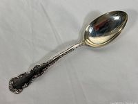 Full view of the 8.5 inch silver serving spoon showing the entire piece including decorative handle and spoon bowl.