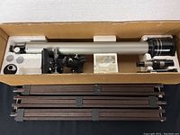 Full view of the telescope optical tube and hardwood tripod parts packed in original box with foam cushioning