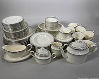Photo showing full set arranged with stacked plates, teacups, saucers, platters, teapot, sugar bowl, creamer, and gravy boat clearly visible.