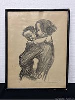 Full frontal view of framed black and white print of a mother holding a child