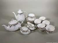 Full set arranged showing teapot, coffee pot, sugar bowl, creamer, cups, and saucers