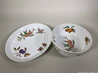 Photo showing the full set of one serving bowl and one platter with detailed fruit pattern decoration on a white background