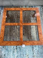 Top down view of the square coffee table showing four square glass panels with wood frames between them.
