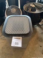 Shows a close-up of the large box air filter with mesh filter on top and two small fans behind it.