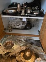 Overall view of two shelves showing trays, bowls, vases, sugar and creamer