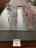 Photo showing arrangement of 12 San Francisco 49ers collectible glasses on a kitchen counter, including tall and tumbler style glasses