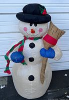 Front view of the inflatable snowman with black hat, scarf, and broom.