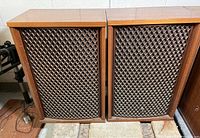 Front view of two Sansui SP-2500 speakers side by side, showing the wooden cabinet and diamond-patterned speaker grills.