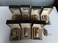 Eight open Citizen branded boxes each containing a gold-tone ladies wristwatch on display cushions.