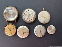 Seven vintage Swiss watch dials and one gold-tone watch case with crystal. Three dials show brand names Viscont, Cytina, and Navy. Condition varies from light wear to heavily worn on the Viscont dial.
