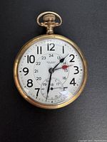 Front view showing white enamel dial, hands, Arabic numerals