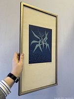 Framed aquatint etching held at angle against wall