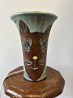 Photo of front angled view of the pottery cat face lamp showing detailed cat facial features and lamp shape.