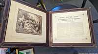 Open book showing two pages, one with large etching depicting religious scene and the other page with explanatory text titled 'Pope Never Dies'.