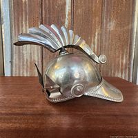 Side and angled view showing front brim and crest detail with riveted edges.