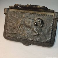 Front view of the cast iron wall box showing dog relief on hinged lid.