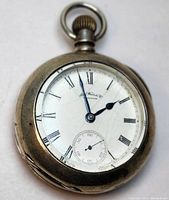 Front view of the pocket watch showing cracked white dial with Roman numeral hour markers and blue hands.