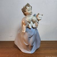 Front view of Lladro My Chubby Kitty figurine showing girl in blue dress holding a cat.